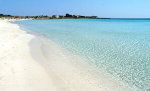 A beach with clear turquoise water and white sand.