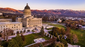 A large government building with a prominent dome, surrounded by a well-maintained lawn and a mountainous backdrop. - Stunning View, Frank Lloyd Wright Inspired Home (Salt Lake City)