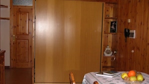 A wooden-paneled room with a dining table set for two, a book, and a fruit bowl. - MOUNTAIN HOLIDAYS 4 SAISON SANTA CATERINA VALFURVA (Santa Caterina)
