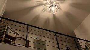 A ceiling with a central light fixture and a staircase with a railing. - La Chouette (Nouziers)