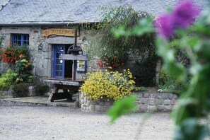 Ein Steinhaus mit einer blauen Tür und einem Schild, auf dem 'AUBERGE' steht.