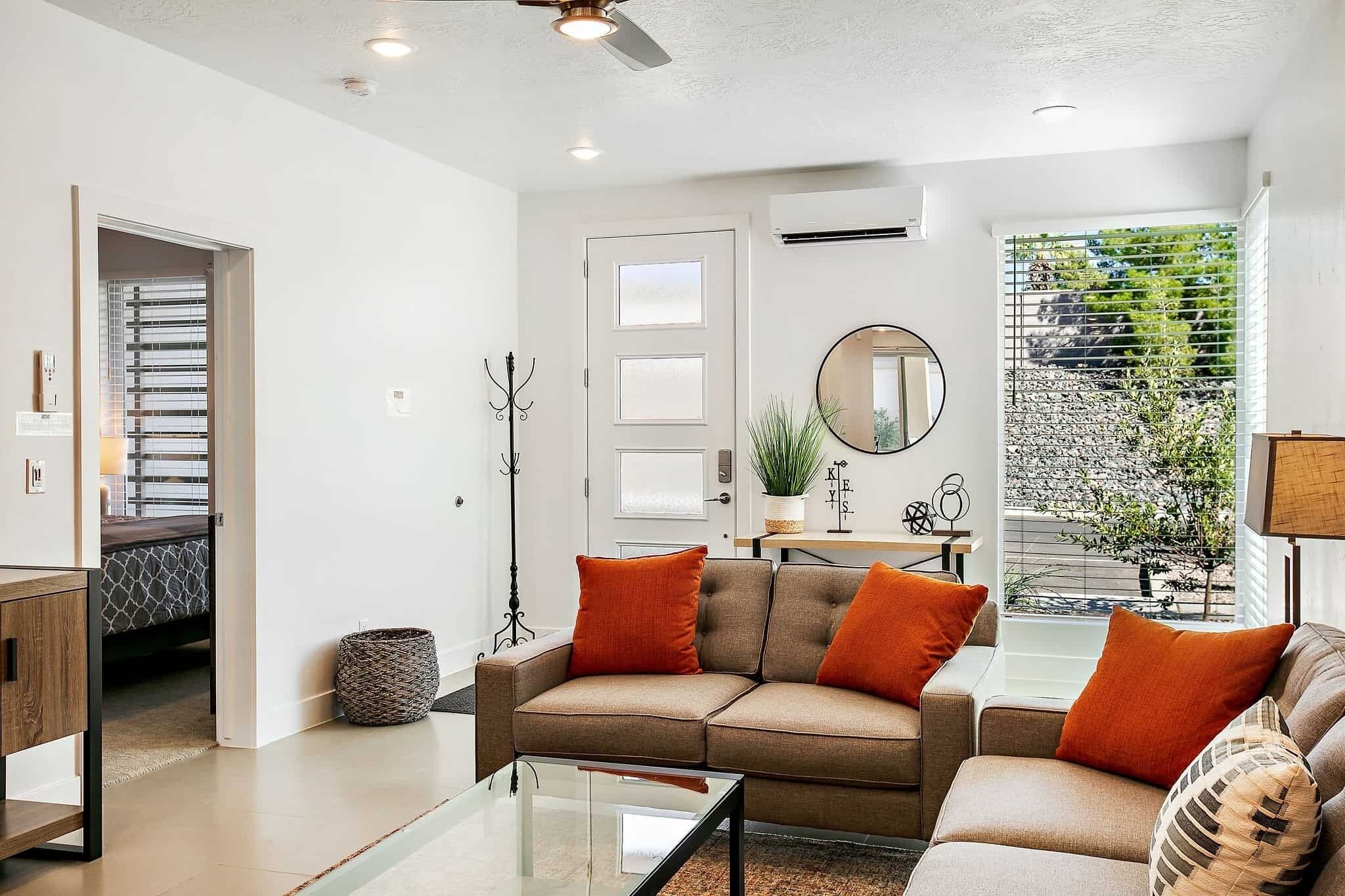 A modern living room with a sofa set, a coffee table, and a view of the outdoors.