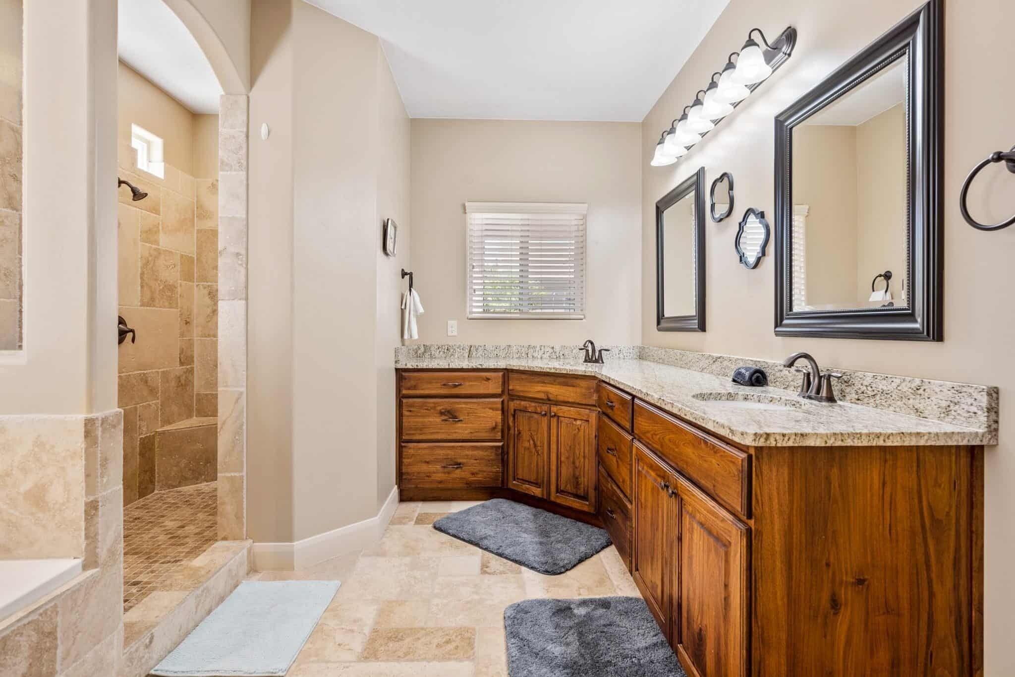 A bathroom with a shower, vanity, and large mirrors.