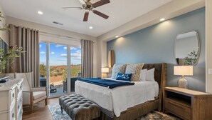 A bedroom with a large bed, a ceiling fan, a nightstand, a dresser, and a view of the outdoors. - Sunset on the 5th 3 Bedroom Townhouse by RedAwning (Washington)