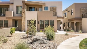 A modern multi-story residential building with a neutral color palette, stone accents, and a landscaped courtyard. - Fun Times & Tan Lines by RedAwning (Washington)
