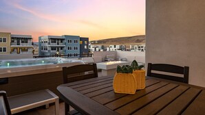 Terraza en la azotea con jacuzzi, zona de estar y vistas a edificios modernos.