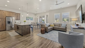 A modern kitchen with wooden cabinets, stainless steel appliances, and a dining area with a chandelier. - Ocotillo Springs #20 by RedAwning (Santa Clara)