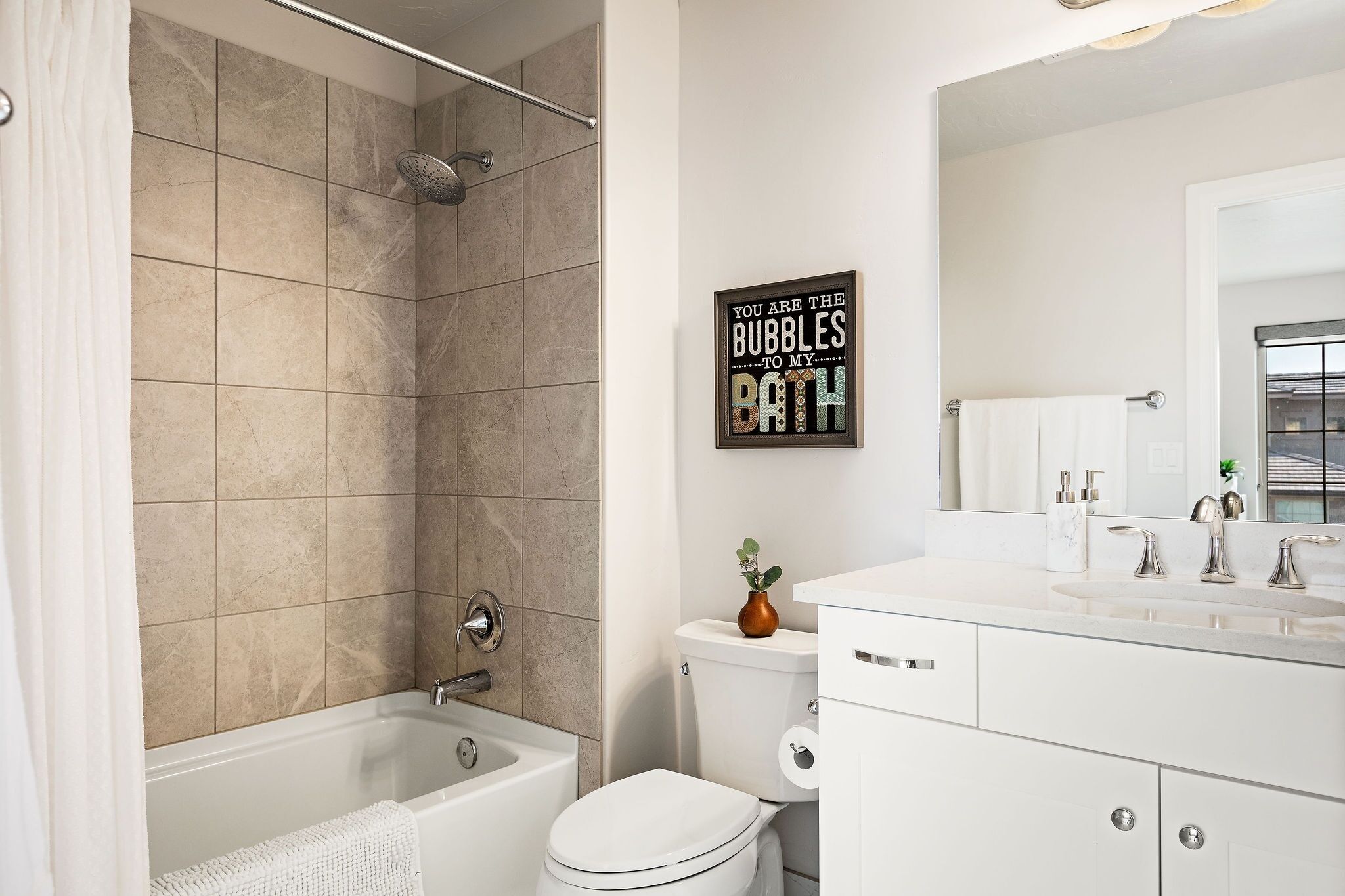A modern bathroom with a bathtub, toilet, and sink.