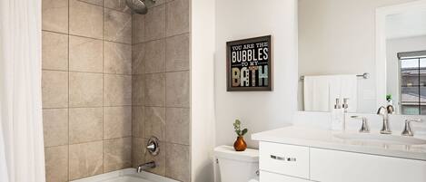 A modern bathroom with a bathtub, toilet, and sink.