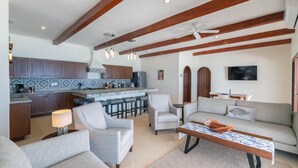 A spacious living area with a kitchen, a dining area, and a seating area with sofas and chairs.