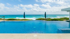 A swimming pool with a view of the ocean and a building in the background.
