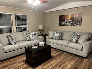 Relax in this stylish living room with two sofas, a coffee table, and a wall-mounted lamp.