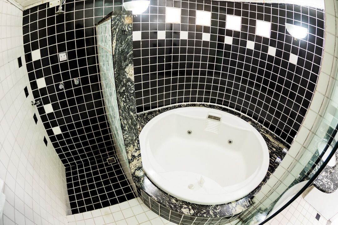 Ein runder Whirlpool mit Wandverkleidung aus schwarz-weißen Fliesen.
