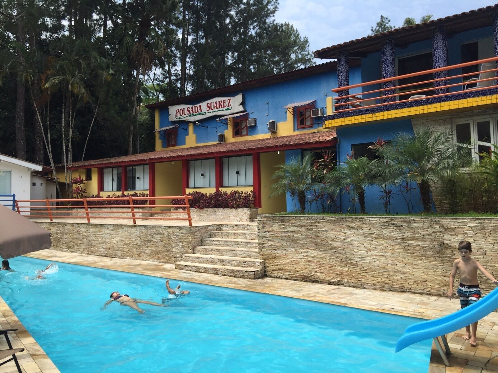Uma área de piscina com um edifício identificado como 
