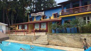 Uma área de piscina com um edifício identificado como