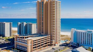 Ein Hochhaus-Hotel mit mehreren Stockwerken, einer Tiefgarage und Blick auf den Strand.