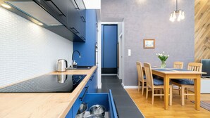 Una cocina moderna con gabinetes azules, encimera de madera y cajón empotrado.