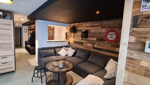Un salon moderne avec un canapé d’angle, une table basse et un coin repas.