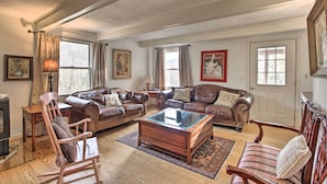 A spacious living room with leather sofas, a glass coffee table, wooden chairs, and a fireplace. - Spacious Faber Home w/ Yard, Steps to Winery! (Faber)