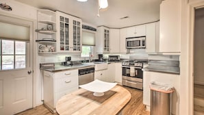A modern kitchen with white cabinetry, a central island, a microwave, a stove, and a ceiling fan. - Spacious Faber Home w/ Yard, Steps to Winery! (Faber)