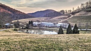 A large building with multiple wings, a pond, and a hilly landscape in the background. - Spacious Faber Home w/ Yard, Steps to Winery! (Faber)