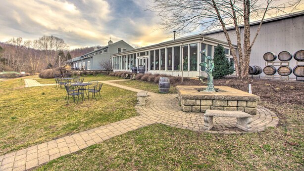 A building with a covered patio area, outdoor seating, and a statue. - Spacious Faber Home w/ Yard, Steps to Winery! (Faber)
