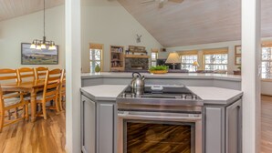 A spacious kitchen with a central island, wooden dining table, and chairs. - BIGS07 - Perfect Family Home in Sunriver, Room for All (Sunriver)