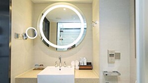 A modern bathroom with a round mirror, a sink, and a toilet. - Lavande Hotels Nanjing Confucius Temple Daguang Road (Nanjing)