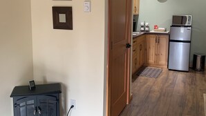 A kitchen with wooden cabinets, a microwave, and a clock on the wall. - Pet Friendly Private Suite in the Mountains (Kelowna)