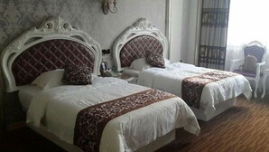 Une chambre d’hôtel avec deux lits, chacun doté d’une tête de lit décorée et de linge de lit blanc.