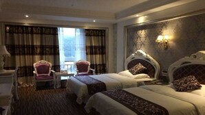 Une chambre d’hôtel avec deux lits, un bureau, une chaise et une fenêtre avec des rideaux.
