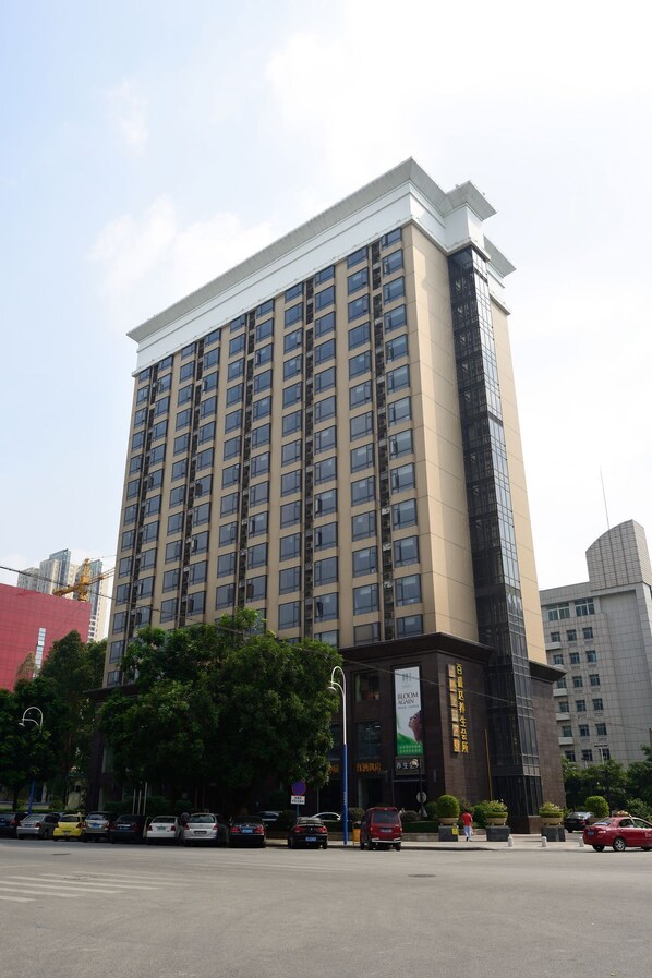 A multi-story hotel with a modern design, featuring a prominent entrance and a large sign.