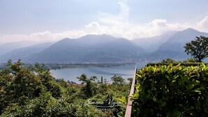 A mountainous landscape with a lake and a church spire in the distance. - Feel at Home - LA TORRICELLA (LOVERE)