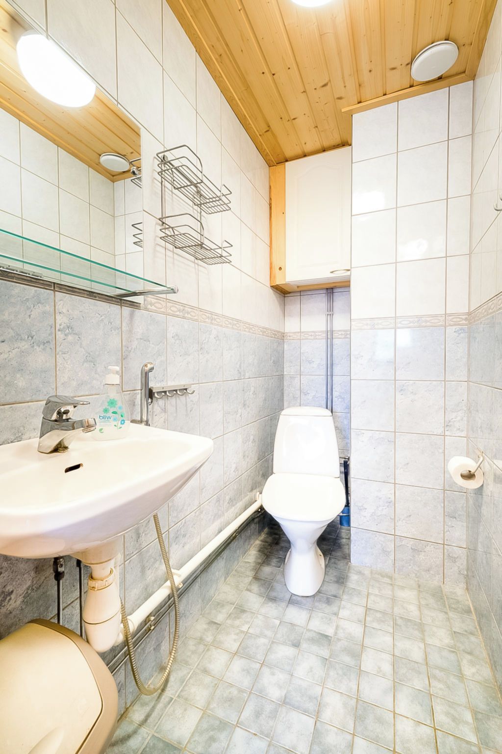 A bathroom with a white sink, toilet, and shower area.