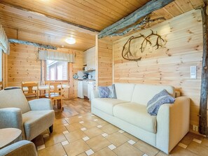 A cozy cabin interior with a wooden ceiling, a dining area, a sofa, and a kitchen. - Vacation home Pajula by Interhome (Äkäslompolo)