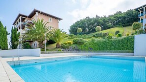 A swimming pool with a clear blue water surface, surrounded by a white tiled deck. - Résidence Soko Eder by Interhome (Saint-Jean-de-Luz)