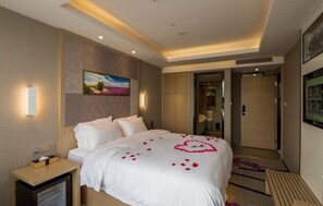 A hotel room with a large bed, a nightstand, a television, and a painting on the wall. - Lavande Hotel Shenzhen Baoan Haiya Binfen City (Shenzhen)