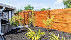 A wooden fence with a garden bed in front. - Zen Retreat w/ Hot Tub & Private Pool - Near Beach! (Panama City Beach)