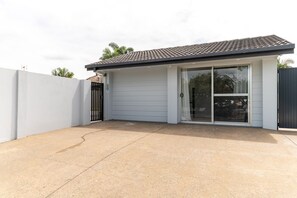 Garage with sliding glass door and covered parking area.