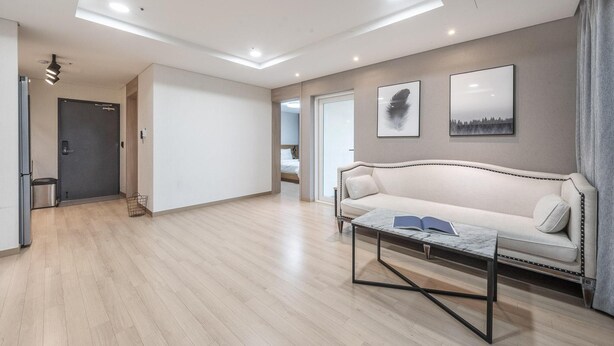 A modern living room with a sofa, coffee table, and artwork on the wall. - Daecheon 2278 Resort (Boryeong)