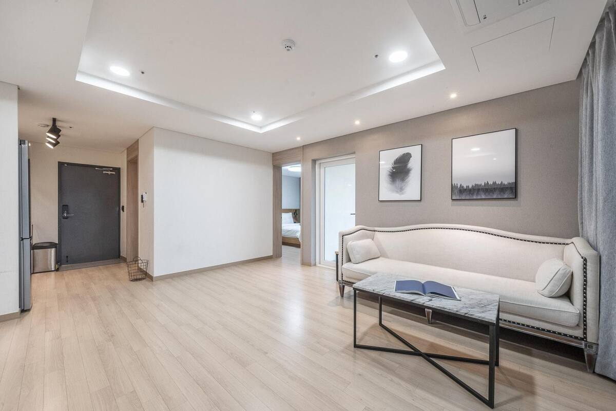 A modern living room with a sofa, coffee table, and artwork on the wall.