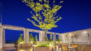 A rooftop terrace with a central tree, seating area, and a bar. - Daecheon 2278 Resort (Boryeong)