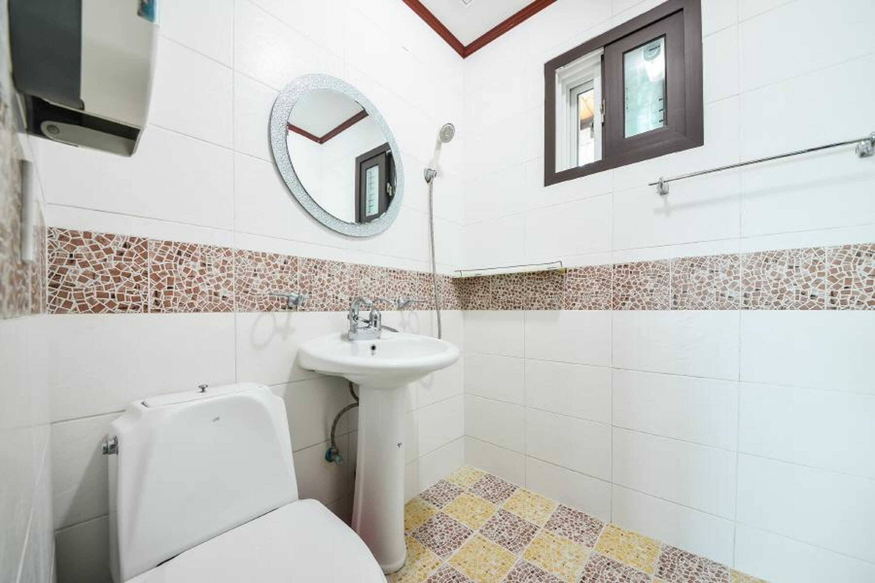 Un baño con inodoro, lavamanos y ducha.