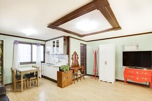 A compact living space with a dining area, kitchenette, and a TV stand. - Ganghwa Pastel Pension (Incheon)