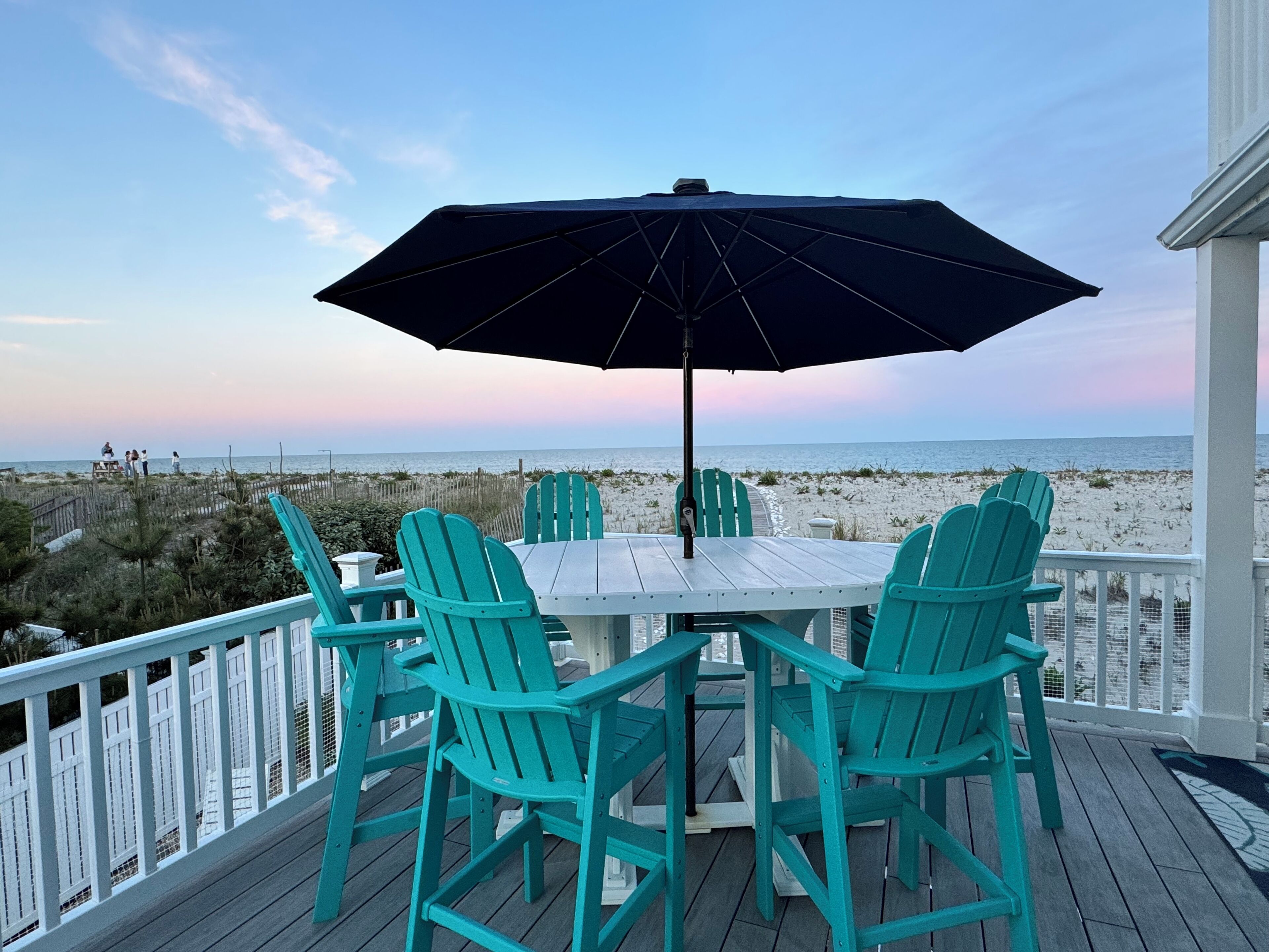 Una terraza con mesa y sillas, con vistas a la playa.