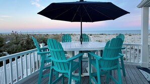 Una terraza con mesa y sillas, con vistas a la playa.