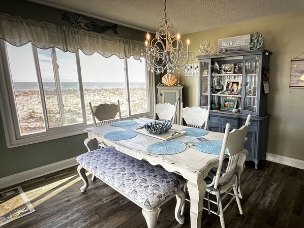 A dining area with a table set for four, a bench, and a view of the beach. - OCEANFRONT! PRIVATE BEACH ACCESS. Yr round RENTALS ! 914-475-1235 (Long Beach)