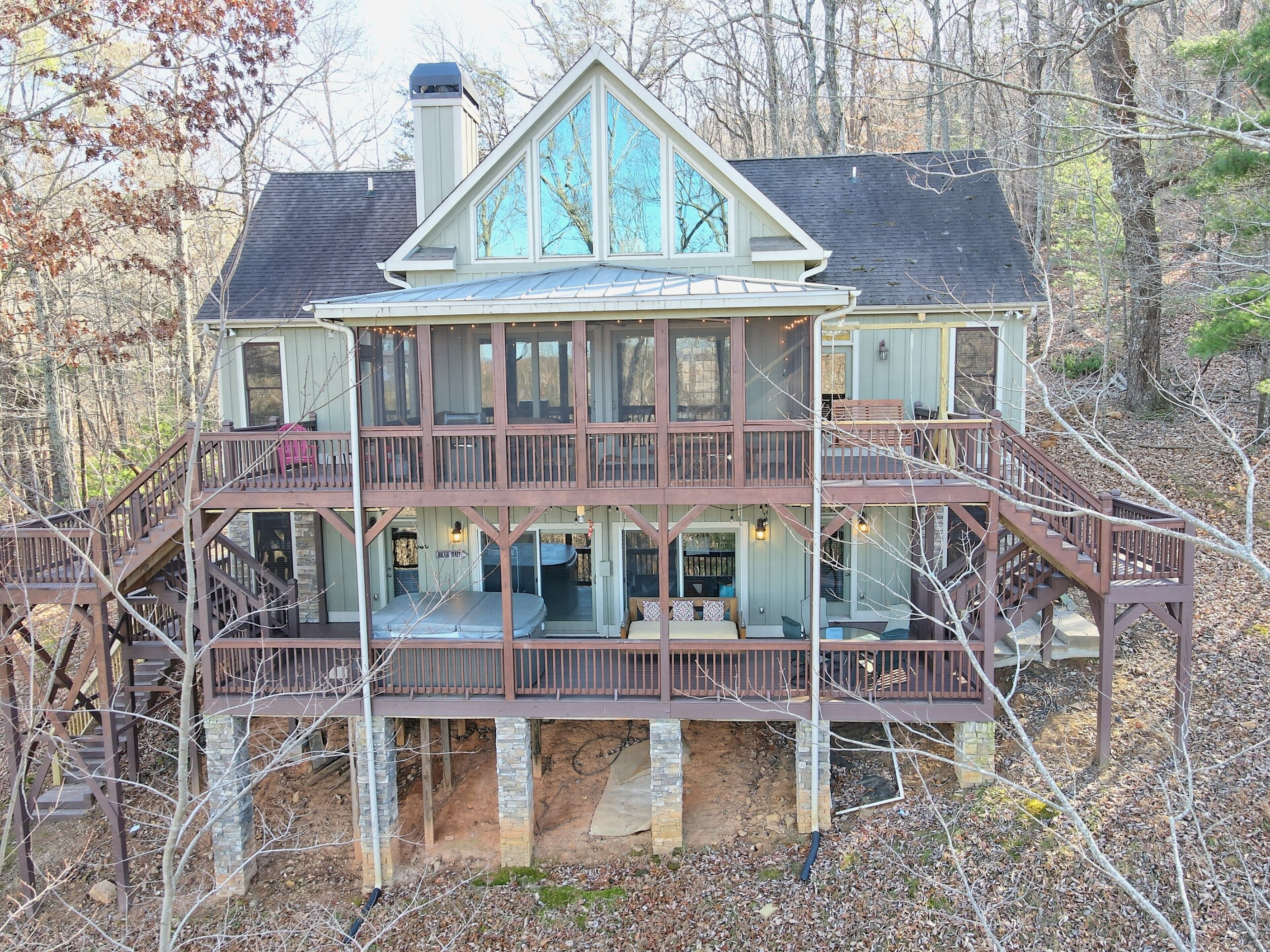 Une grande maison à étages, dotée d’un balcon imposant et d’une véranda qui fait le tour de la maison.