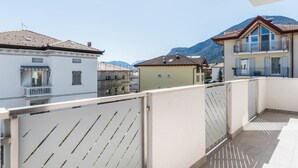 Ein Balkon mit Blick auf Gebäude und Berge.
