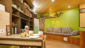 A kitchen with a dining area, a refrigerator, a coffee maker, and a sofa with patterned cushions. - Finca "La Alpispa" with Pool, Fast Wi-Fi, Terrace & Garden (Valleseco)